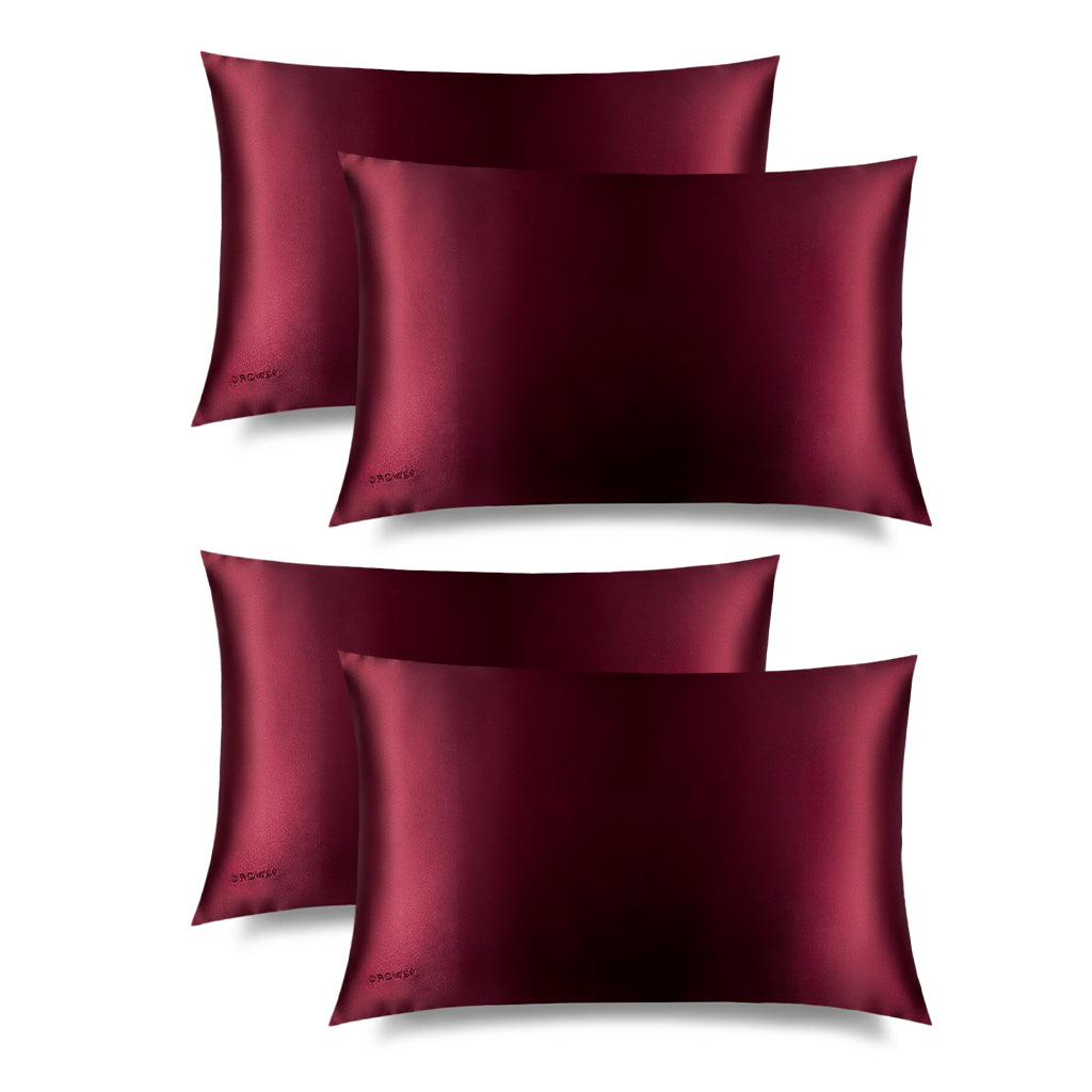 Four La Vie En Rouge Silk Pillowcases by drowsysleepco are arranged in two rows on a white background. Each smooth, burgundy pillowcase has a discreet logo in one corner, ideal for hair protection.