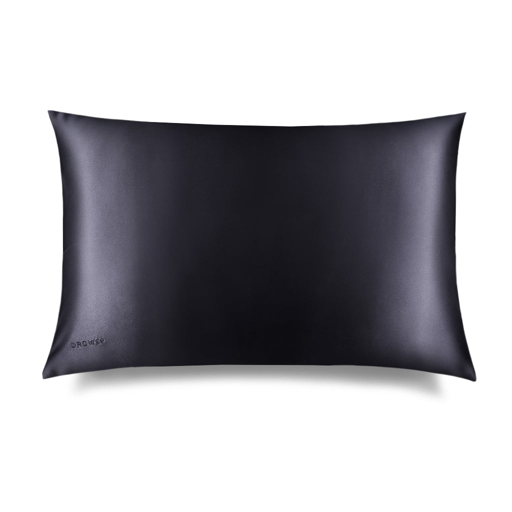 The Moonlight Shadow Silk Pillowcase by drowsysleepco is a rectangular black case with a smooth, shiny finish and minimal design. The brand name appears subtly in one corner. Photographed against a white background, it’s a skincare essential.