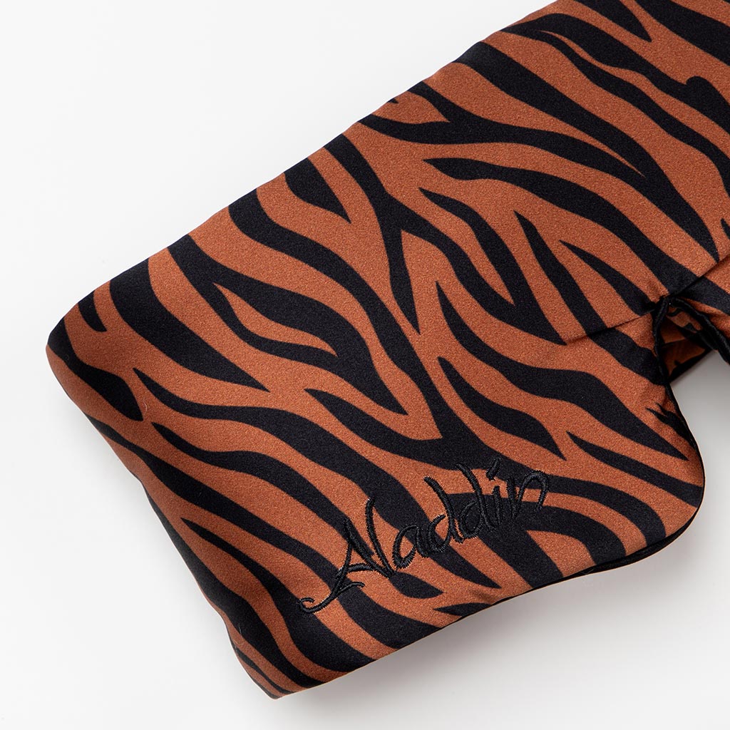 A close-up of the drowsysleepco Rajah Sleep Mask, featuring brown and black zebra stripes on mulberry silk with "Aladdin" embroidered in black. The soft mask is draped on a white background, offering luxurious comfort for restful sleep.