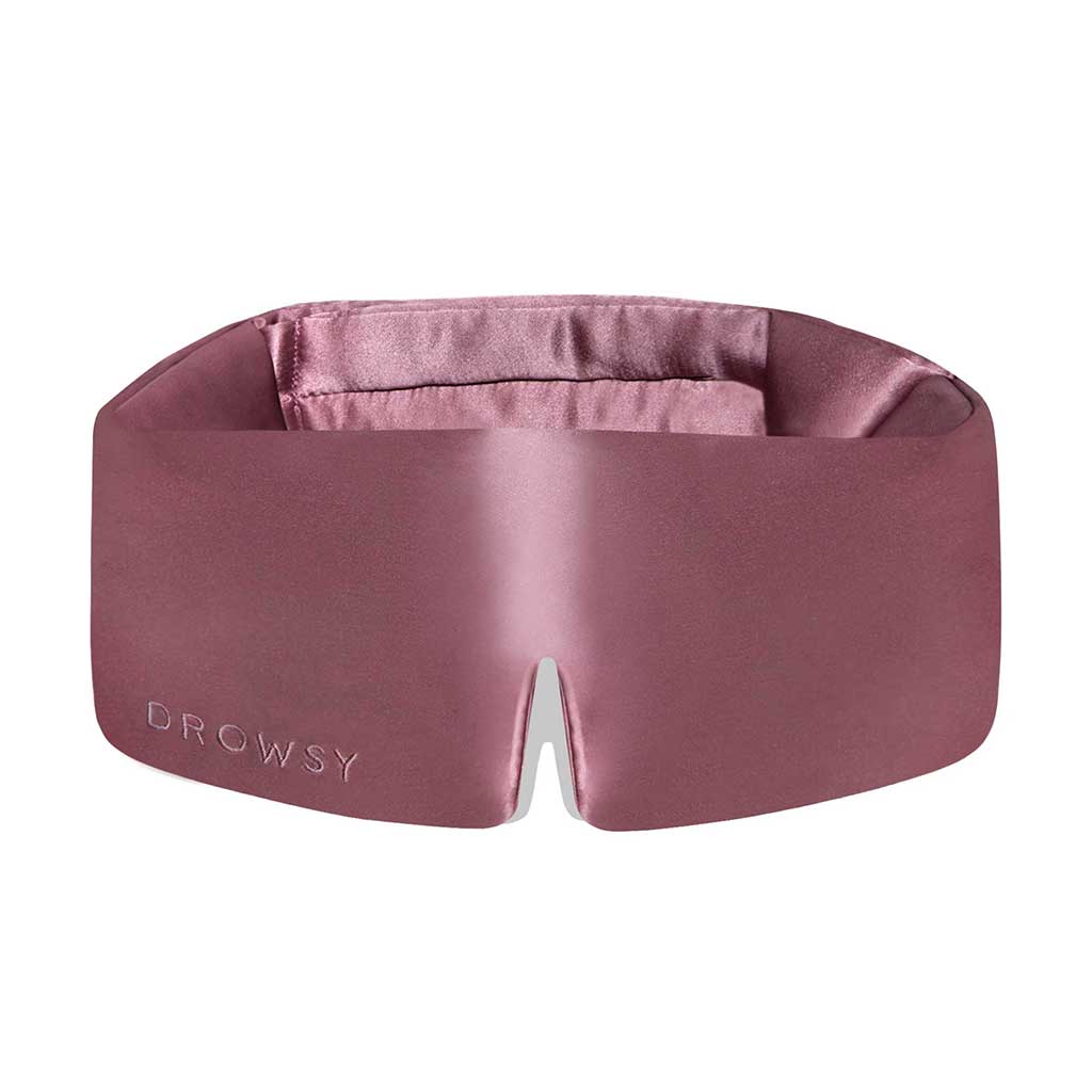 The Damask Rose eye mask by drowsysleepco is mauve mulberry silk, features DROWSY embossed on the left and a small notch at the bottom center. Soft, padded, and crafted for comfort.