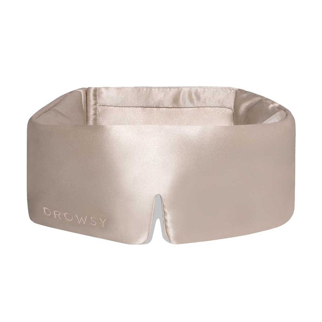 The Dusty Gold sleep mask by drowsysleepco is a beige silk blackout eye mask with a wide, padded design and small bottom notch—ideal for uninterrupted beauty sleep.