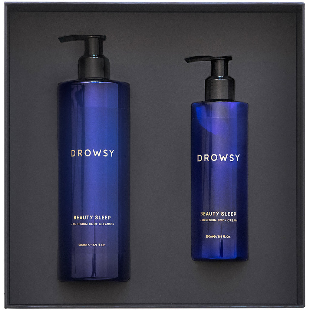 Two blue drowsysleepco bottles—the Beauty Sleep Ritual—sit side by side in a black box: a larger sleep-focused body wash and a smaller pre-sleep body cream.