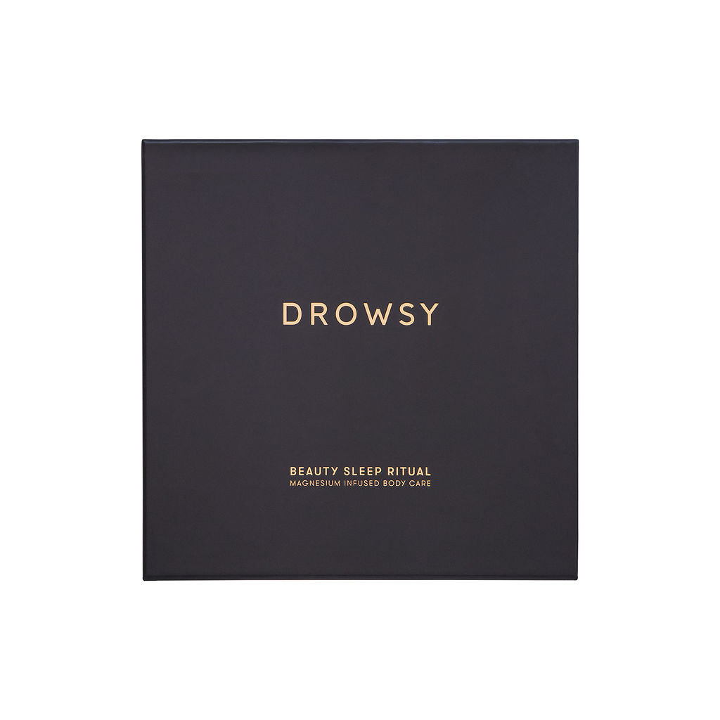 A dark square box with gold text reading drowsysleepco and Beauty Sleep Ritual on the lid suggests luxurious magnesium-infused body care for a restful night.