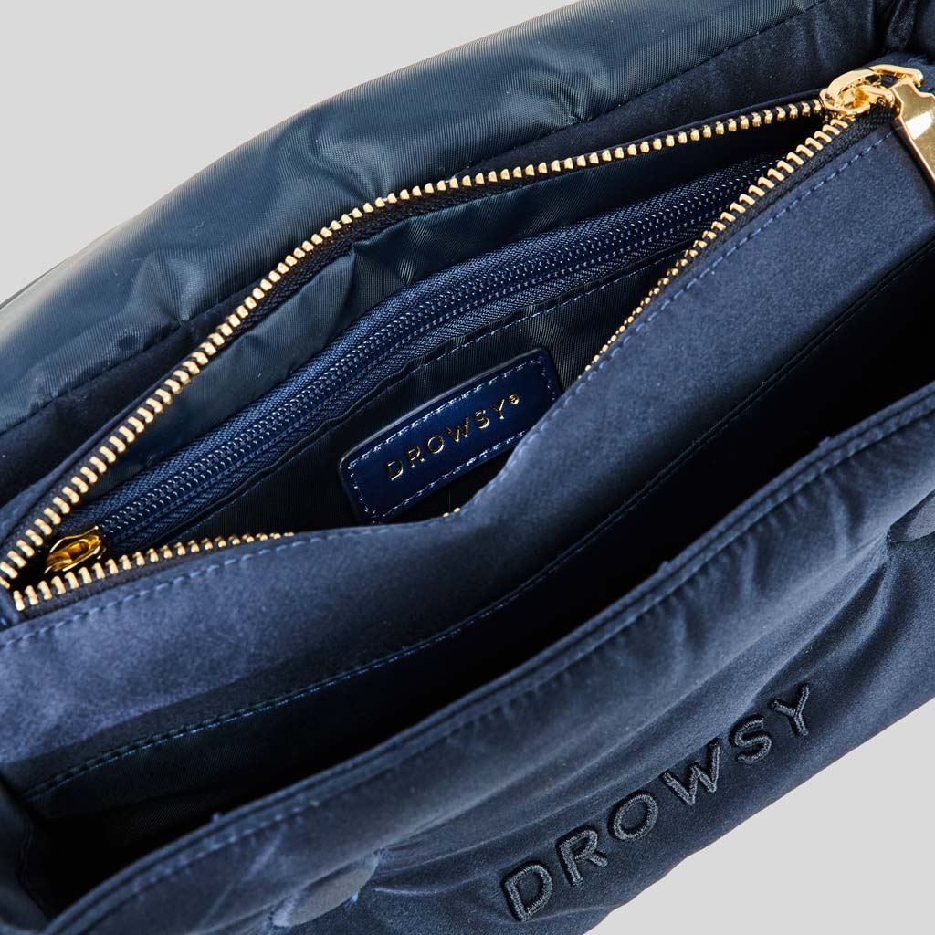 The Perfect Escape Bundle - Midnight Blue by drowsysleepco features a soft, padded navy bag with gold zipper, inner pocket, and stitched DROWSY branding—ideal for carrying your silk sleep mask or beauty essentials on the go.