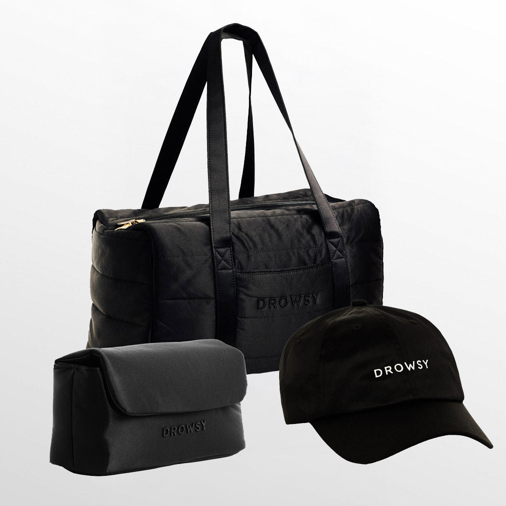 The Drowsy Weekend Collection - Black Jade features a quilted duffel bag, travel pouch, and baseball cap, all in black with white “Drowsy” branding—ideal for stylishly organizing and packing your getaway essentials.