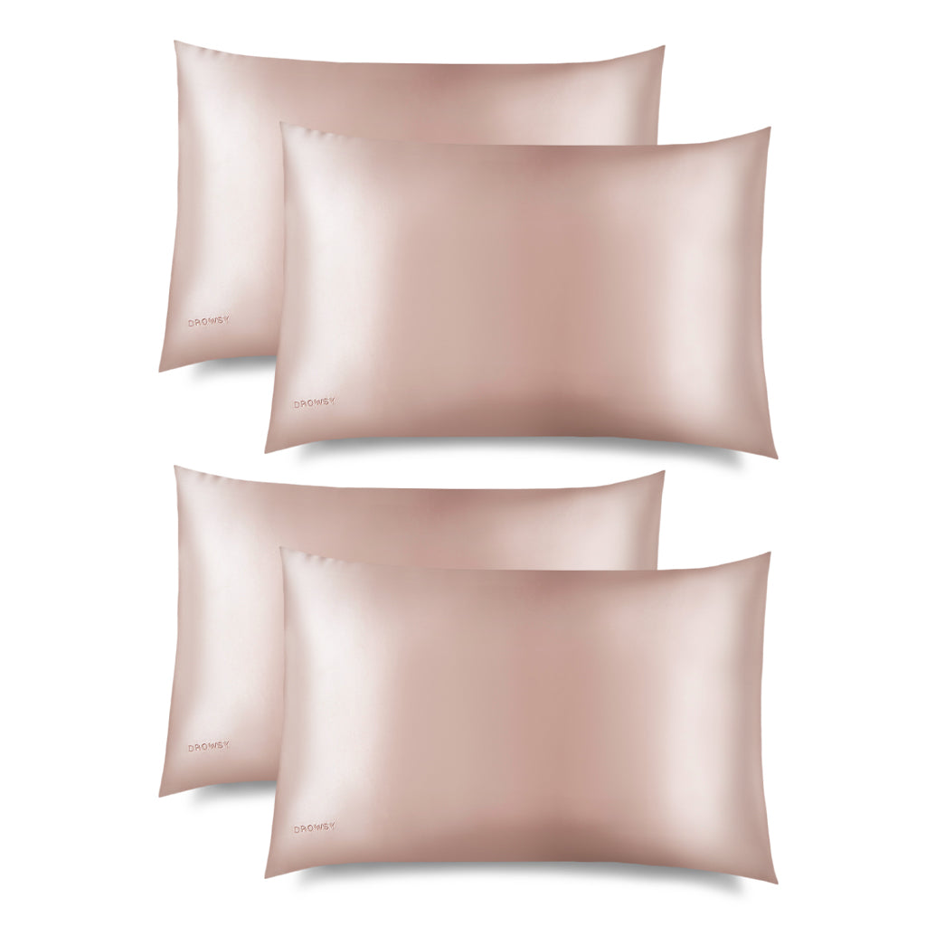 Four Sunset Pink Silk Pillowcases by drowsysleepco are displayed in two rows against a white background, each featuring a subtle logo in the bottom left corner. These silk cases help protect hair while you sleep.