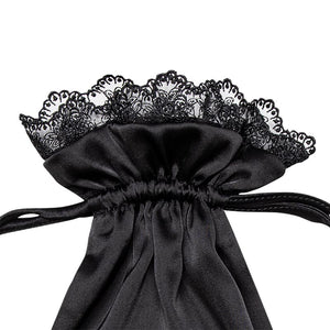 Introducing the Paris Love Story Carry Pouch by drowsysleepco—a black satin drawstring bag adorned with couture-inspired lace ruffled trim and secured with a matching black ribbon, ideal for storing your silk sleep mask or adding a touch of Parisian elegance to your routine.