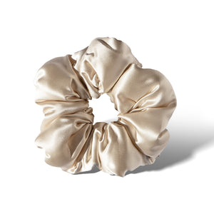 The drowsysleepco Rajah Padded Scrunchie, in shiny light beige satin with soft folds and a smooth texture, is displayed on a white background.
