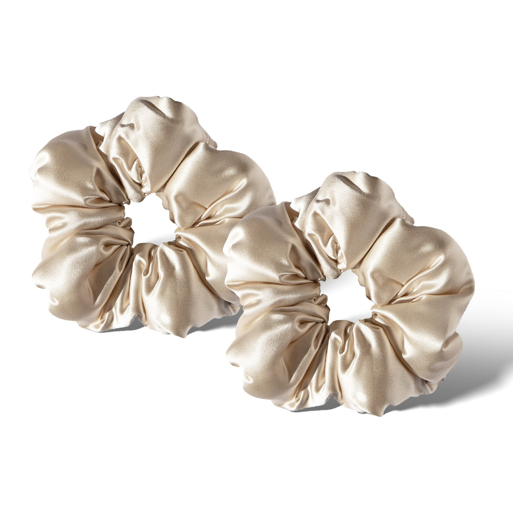 Two Rajah Padded Scrunchies by drowsysleepco in beige satin, featuring a smooth and shiny finish, are placed side by side on a white background with subtle shadows.