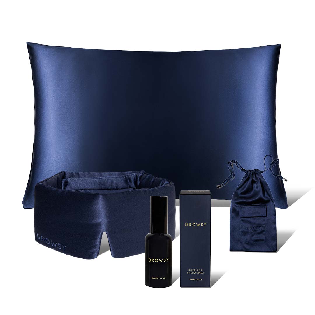 The Midnight Ritual Bundle Midnight Blue by drowsysleepco includes a silk sleep mask, pillowcase, SOS spray, drawstring pouch, and product box—all elegantly displayed against a white background for a luxurious touch.