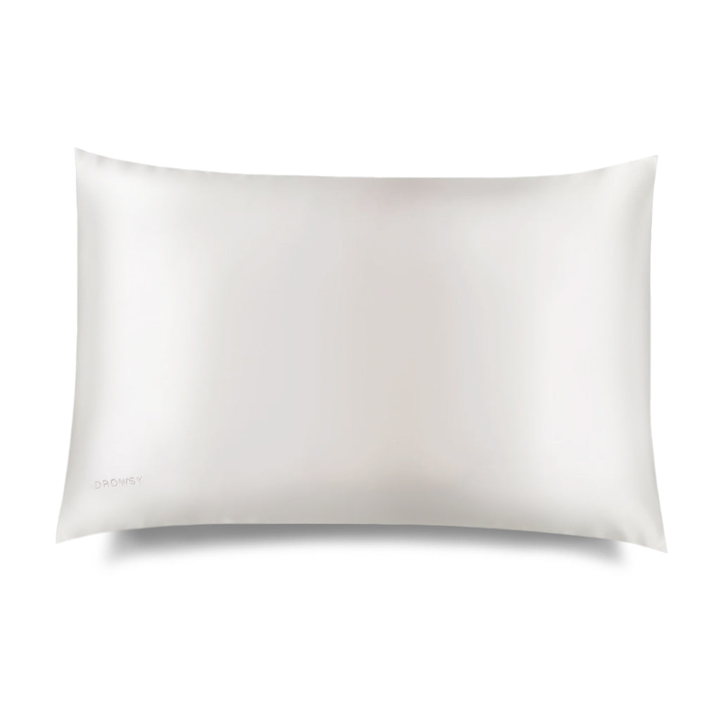 A rectangular, white Akoya Pearl Silk Pillowcase by drowsysleepco is shown against a white background. This hair-protecting, smooth and subtly lustrous accessory appears soft and luxurious, with the brand name faintly visible in one corner.