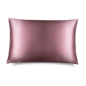 The Damask Rose Silk Pillowcase by drowsysleepco is a rectangular, mauve-colored pillowcase with a subtle sheen. "DROWSY" is printed in small letters in one corner, making it an ideal hair and skin care essential.