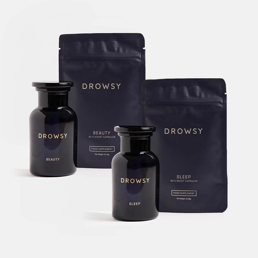 Two dark glass jars and two resealable pouches from drowsysleepco’s Supplements - Beauty Sleep Clinic are shown against a white background—ideal for anyone seeking a restorative sleep supplement.