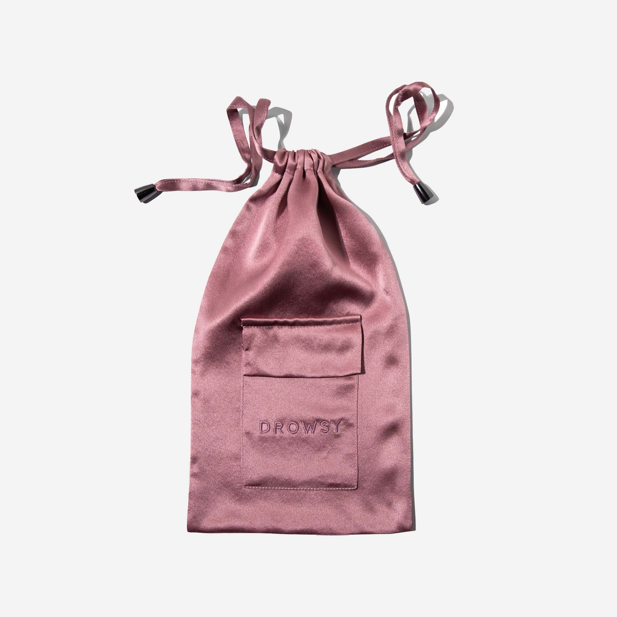 A mauve satin drawstring pouch with a stitched pocket and the word DROWSY embroidered on the front, displayed on a white background.