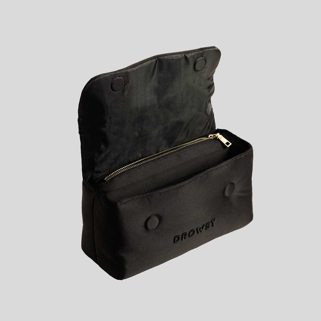 A black zippered pouch with snap buttons and drowsysleepco embroidered on the front, shown open—ideal for storing your Perfect escape bundle - Black Jade essentials—against a plain gray background.
