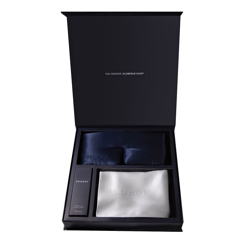 The drowsysleepco Beauty Sleep Experience includes a navy silk sleep mask, a white mulberry silk pillowcase, and a deep sleep pillow spray in a luxury gift box with “You deserve glorious sleep” on the inside lid.
