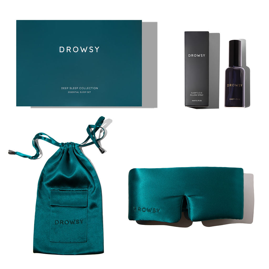 The drowsysleepco Green Sapphire Deep Sleep Collection includes a box, satin pouch, luxury silk sleep mask, and deep sleep pillow spray in black packaging—all beautifully arranged on white for perfect sleep essentials.
