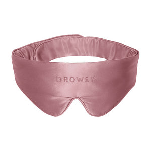 The Damask Rose Featherweight Silk Sleep Mask by drowsysleepco is a silky pink mulberry silk mask designed to cover your eyes and block out light for better sleep, featuring the word “DROWSY” embroidered on the front.