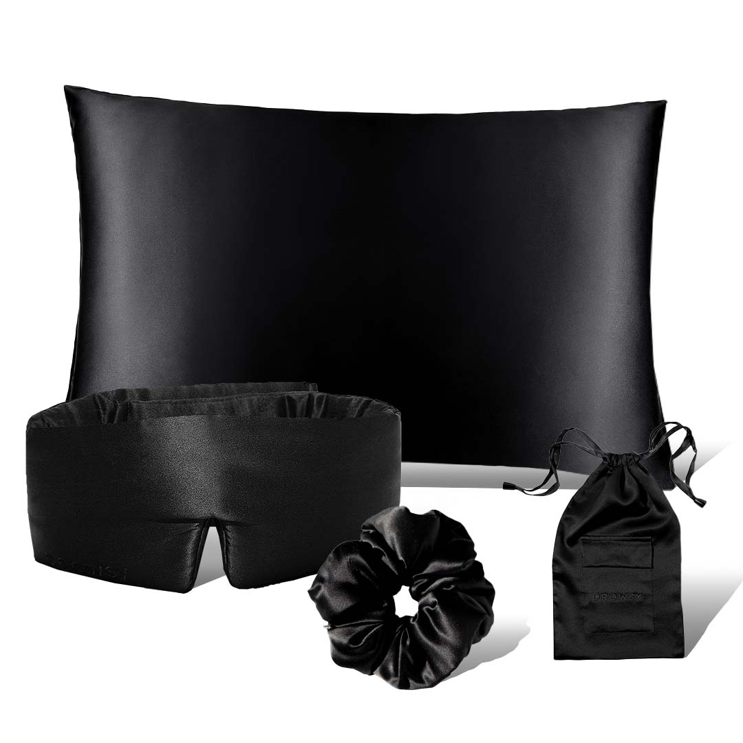 The Drowsy is the new black bundle by drowsysleepco features a black satin pillowcase, eye mask, scrunchie, and drawstring pouch—perfect sleep accessories displayed on a white background for ultimate beauty rest.