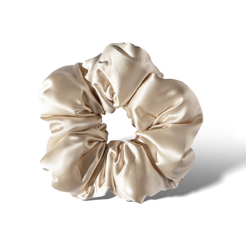 The drowsysleepco Rajah Padded Scrunchie, in shiny light beige satin with soft folds and a smooth texture, is displayed on a white background.